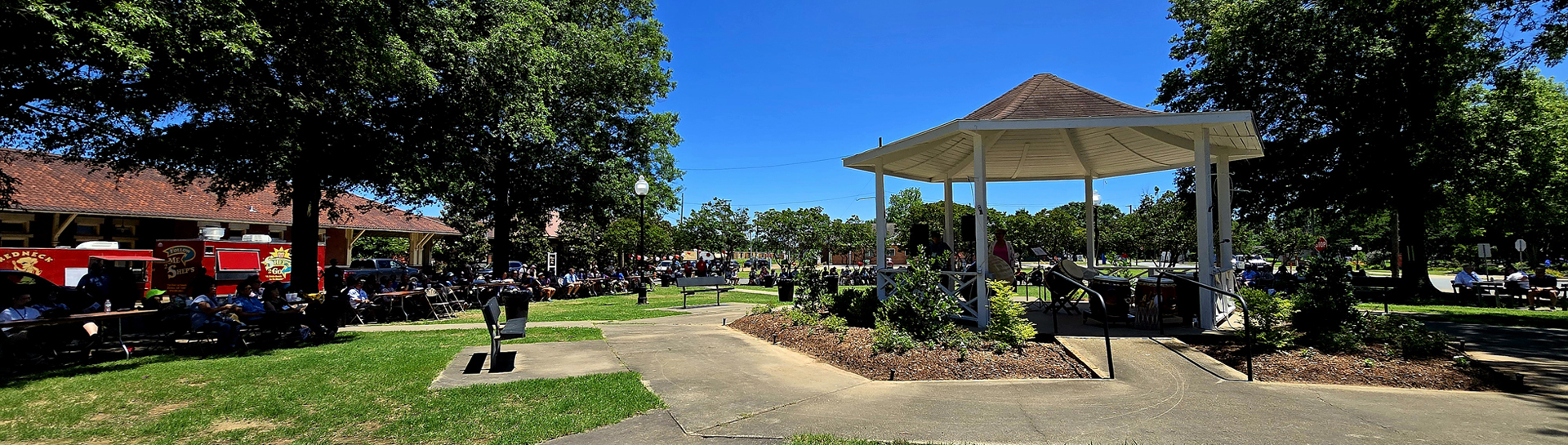view of pilgrims at program in McGehee.  A small stage is included